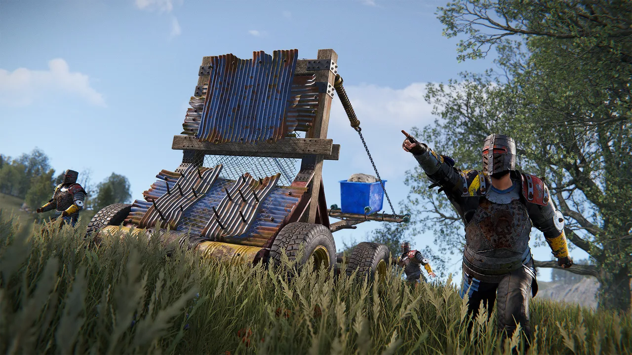 Катапульта в Rust, заряженная каменным снарядом, стоит на поле перед деревянной базой в примитивном режиме